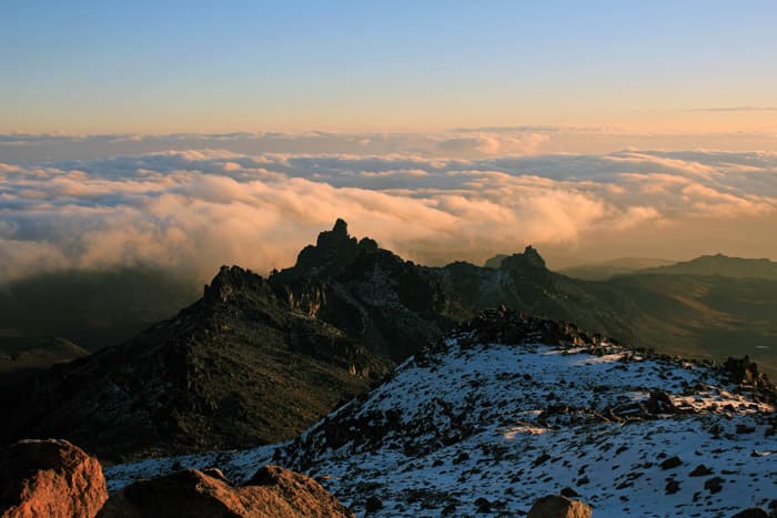 Rugged rocky peaks of Mount Kenya against blue equatorial skies