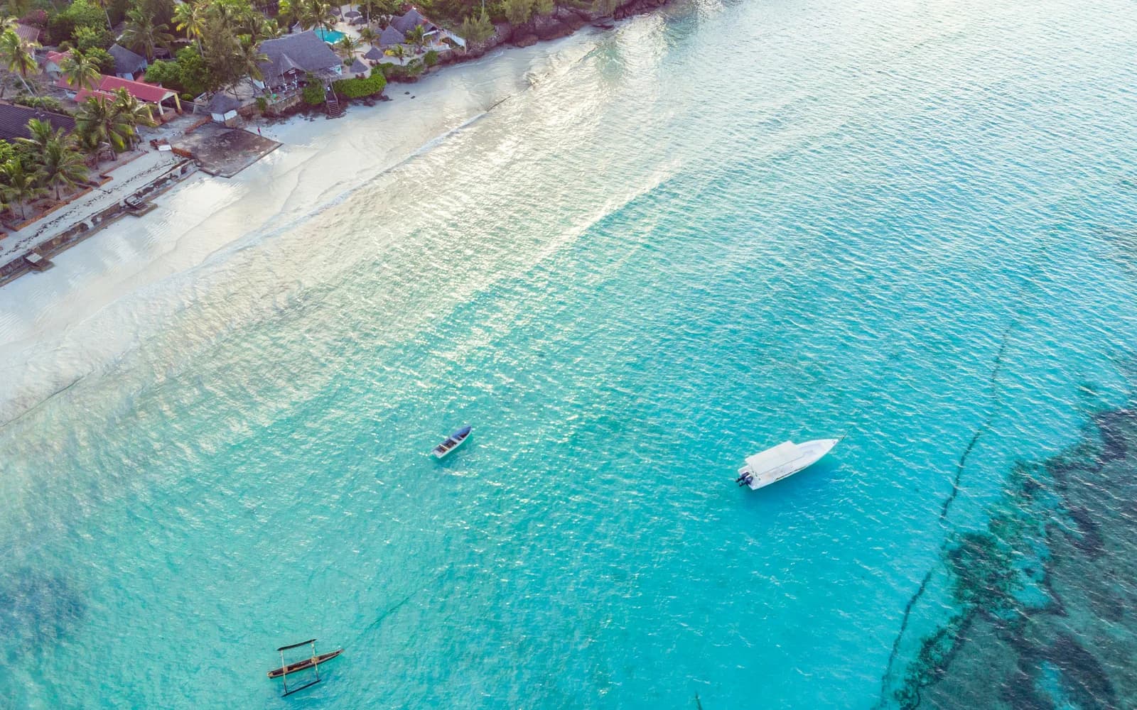 Aerial view of a white-sand Zanzibar coastline and turquoise sea